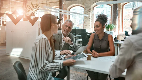 Lluvia de ideas. Grupo de gente moderna discutiendo algo y trabajando juntos en la oficina creativa — Foto de Stock