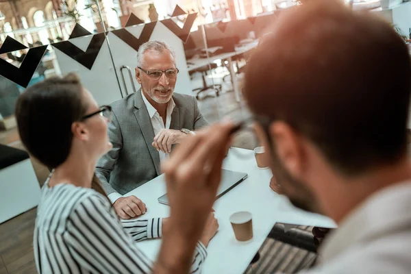 Office workers. Group of business people discussing something while sitting at the office table together — Stock Fotó