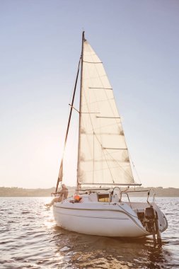 En iyisi rahatla. Yelkenli ya da yatın güvertede rahat bir şekilde oturduğu yatın görüntüsü.