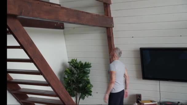 Thuis trainen. Atletische en sterke volwassen man doen pull-ups oefeningen op houten horizontale bar thuis — Stockvideo