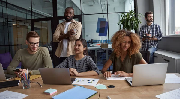 Brainstorming. Framgångsrikt affärsteam, grupp glada multiraciala medarbetare som delar med sig av idéer, arbetar med projekt tillsammans medan de sitter i det moderna coworking utrymmet — Stockfoto