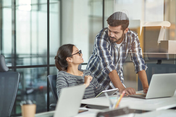 Разговариваю на работе. Молодые коллеги-женщины и мужчины разговаривают и обсуждают проект, работают вместе в современном коворкинговом пространстве