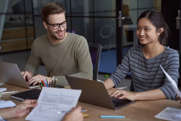 Travailler ensemble. Jeunes collègues heureux féminins et masculins, collègues heureux travaillant sur des ordinateurs portables et communiquant tout en étant assis dans l'espace de coworking moderne — Photo