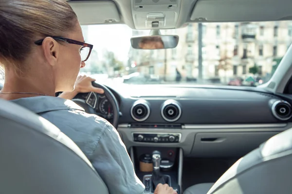 Widok na biały biznes kobieta siedzi za kierownicą samochodu, bezpiecznie jazdy w mieście — Zdjęcie stockowe
