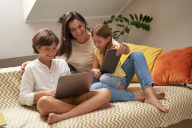 İnternetten çizgi film izliyorum. Genç, güzel, beyaz bir aile, anne ve iki tatlı çocuk kanepede oturup dizüstü bilgisayara bakıyorlar.