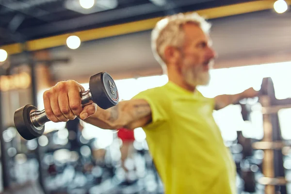 Passar över femtio. Sidovy över en mogen kaukasisk man som tränar med hantlar på gym, fokus på handen — Stockfoto