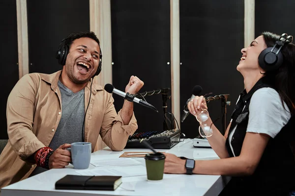 Portait de dos presentadores de radio, hombre y mujer riendo mientras hablan entre sí, moderando un espectáculo en vivo en el estudio —  Fotos de Stock