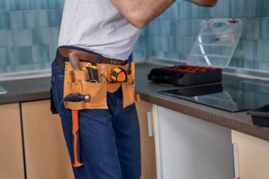 Kemeri tamir aletleriyle dolu bir adam.