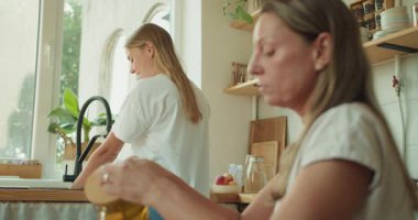 Sıcak bir mutfak sahnesi arkadaşlığın sevincini ve birlikte aşçılık faaliyetlerini gösteriyor.