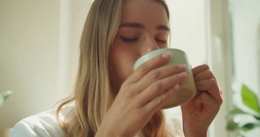 Sıcak bir içecek yudumlarken, bu huzurlu ve huzurlu an evde rahatlık ve rahatlığı güzel bir şekilde özetliyor.