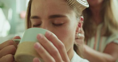 Güzellik rutininin ortasında sakin bir dinlenme anı saç şekillendirme ve kahve yudumlamayı da içeriyor.