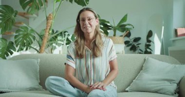 Sıcak, davetkar bir atmosferi somutlaştıran, tropikal bitkilerle çevrili, dost canlısı bir kadın..