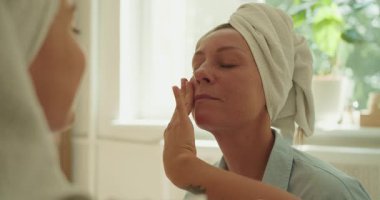 Rahatlatıcı bir yüz masajı seansı yaşayın. Huzurlu bir ortamın sakinliğinden zevk alan iki kadın.