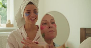 Renkli yüz maskeleri ve arkadaşlarımla neşeli kahkahalarla nefis bir kişisel bakım rutininin tadını çıkarıyorum.