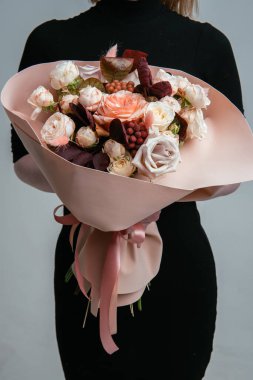 Şeftali köpüklü çiçek buketi, arka planda bir çiçekçinin elinde. Rosa, cotinus, brunia, lagurus.