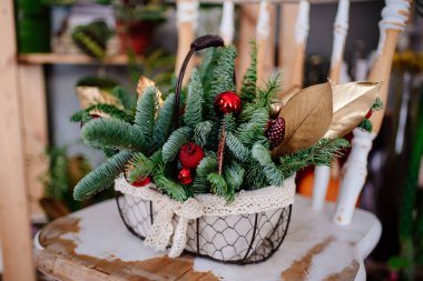 Hasır sepetin içinde köknar dallarıyla eski ahşap sandalyede kompozisyon