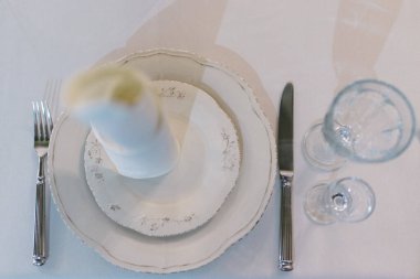 Şölen salonunda düğün dekoru. Bayram masası, tabak, peçete, bıçak, çatal servis ediliyor. Masa dekorasyonu. Romantik Akşam Yemeği ya da diğer etkinlikler.