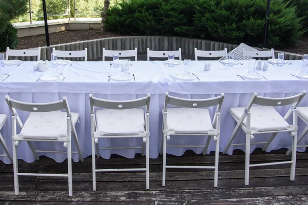Fehér Szolgált Asztal Sok Székkel Szabadban Háttérben Zöld Fák — Stock Fotó