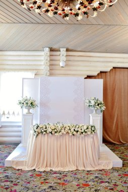 Restoranda düğün başkanlığı, boş yer. Çiçekli, yeşillikli, şeftalili yeni evliler için düğün yemeği masası. Düğün masasında yemyeşil çiçek aranjmanı. Lüks düğün süslemeleri