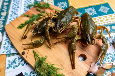 Mavi bir masa örtüsünün üzerinde tahta bir tahtanın üzerinde canlı bir kerevit.