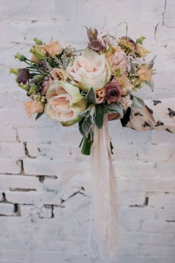 Açık arkaplanda ipek kurdeleli amarilis buketi