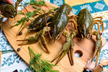 Mavi bir masa örtüsünün üzerinde tahta bir tahtanın üzerinde canlı bir kerevit.