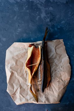 İki pembe somon balığı. Esmer arka planda kağıt üzerinde füme balık.