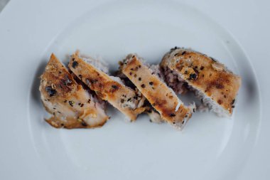 Dilimlenmiş ton balıklı fileto beyaz tabakta baharatlı.