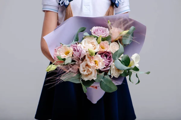 Ένα Μπουκέτο Λουλούδια Συσκευασμένα Μωβ Χαρτί Στα Χέρια Ενός Κοριτσιού — Φωτογραφία Αρχείου