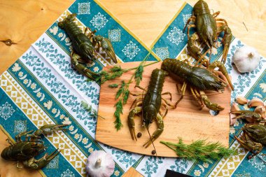 Mavi bir masa örtüsünün üzerinde tahta bir tahtanın üzerinde canlı bir kerevit.