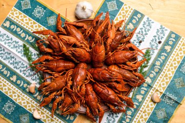 Ahşap bir masanın üzerinde mavi bir masa örtüsü üzerinde kaynatılmış kerevit.