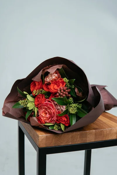 Boeket Bloemen Bordeaux Verpakking Houten Stoel Lichte Ondergrond Rosa Skimmy — Stockfoto