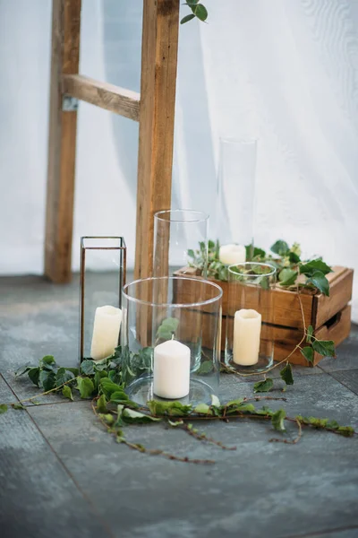 Düğün kemerinin dekorasyonunun bir parçası. Cam silindirlerde beyaz mumlar