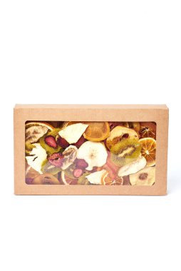 Kurutulmuş meyveleri kağıt dikdörtgen bir kutuya koyup beyaz arka planda şeffaf bir kapakla karıştır. Vejetaryen yaşam tarzı.