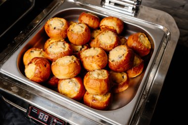 Gümüş renkli buhar masası, siyah arka planda porsiyonlu sıcak jülyen.