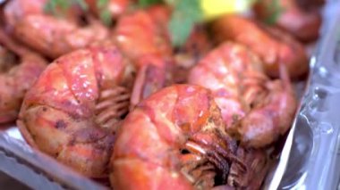 Kızarmış Langoustine, dilimlenmiş limon ve dereotlu, masada plastik kutuda. HD