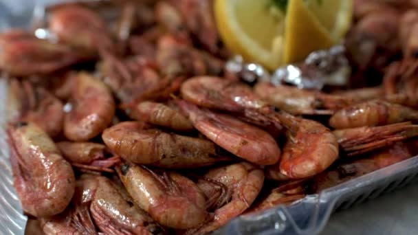 Gros plan crevettes frites avec citron coupé et aneth dans une boîte en plastique sur la table. HD — Video