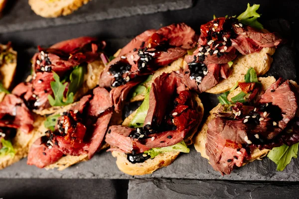 Fırında sığır eti, roka ve balzamik soslu siyah masa.