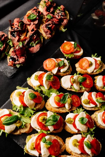 Mozzarella, domates, pesto sosu ve fırında sığır eti, roka ve balzamik soslu bruschetta.