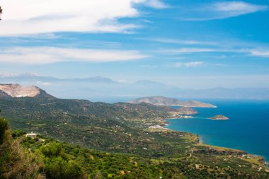 Mirabello körfezinin güzel manzarası. Sitia ve Agios Nikolaos'un yakınında. Turkuaz deniz, dağlar ve yeşil doğa ile peyzaj.