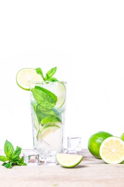 Taze limonlu mojito kokteyli, nane yaprakları ve ahşap zemin üzerinde şeffaf bir bardakta buz küpleri. İçecekleri tazeliyorum. Beyaz arkaplanda izole.