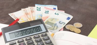 Hesap makineli banknotlar ve paralar. Tahta arka planda Euro banknotları. Vergi, kâr ve maliyet için fotoğraf. 50 Euro, 20 Euro, 10 Euro. Para ve finans