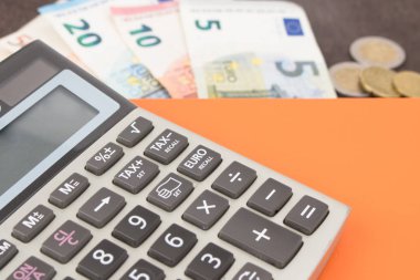 Hesap makineli banknotlar ve paralar. Tahta arka planda Euro banknotları. Vergi, kâr ve maliyet için fotoğraf. 50 Euro, 20 Euro, 10 Euro. Para ve finans