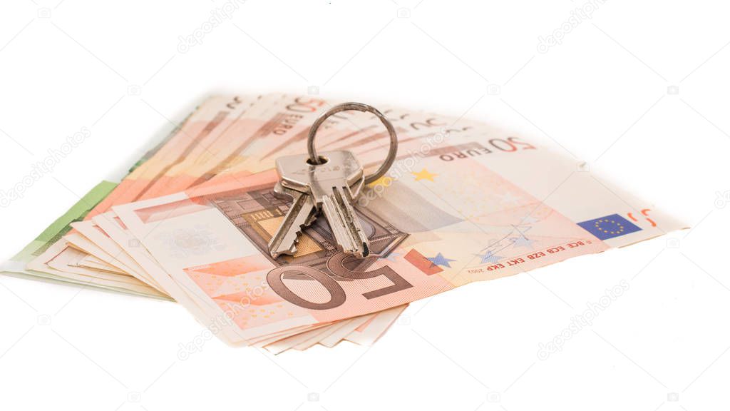 Keys to the apartment on the background of banknotes. Euro banknotes 50 fifty. Isolated money on white background.