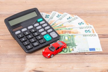 Sigorta, kredi ve araba konsepti. Kırmızı araba ve euro banknotları. Hesap makinesi, avro parası ve kırmızı araba. Uzayı metin için kopyala. Arabanın maliyetini hesapla.