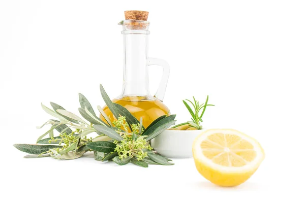 Bir şişe kaliteli saf zeytinyağı, limon ve beyaz arka planda izole edilmiş zeytin dalı..