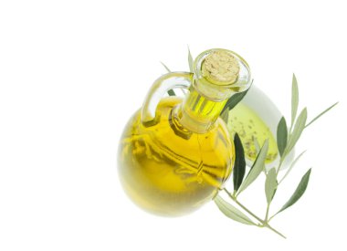 Zeytin yağı şişesi ve zeytin dalı uzatılmış kase. Bakir zeytinyağı. Doğal zeytinyağı, sağlıklı yiyecekler. Doğal Akdeniz yiyeceği. Ekmek batırma.