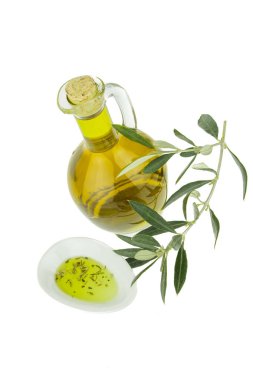 Bitkisel bitkilerle zeytinyağı ve zeytin dalı ile kase tabağı. Bakir zeytinyağı. Doğal zeytinyağı, sağlıklı yiyecekler. Doğal Akdeniz yiyeceği. Ekmek batırma.