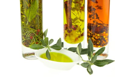 Zeytin yağı kasesi, zeytin dalı ve arka planda baharatlar. Bakir zeytinyağı. Doğal zeytinyağı, sağlıklı yiyecekler..