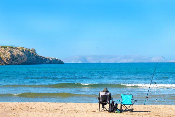 Two fishing chairs on the beach. Fishing on the beach, Mediterranean sea Greece. Copy space.